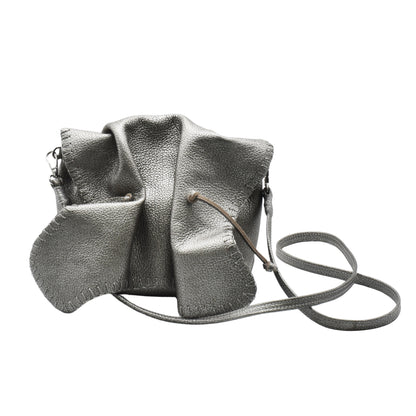 Close-up of textured pink leather surface with intricate floral embossed pattern on Butterfly Bag, showcasing detailed