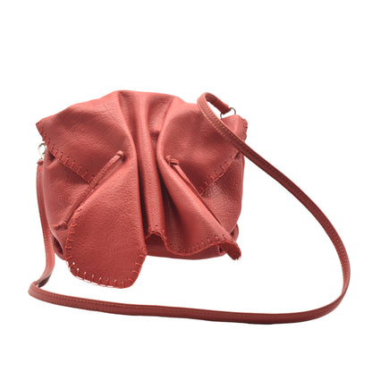 Close-up of the Butterfly Bag’s textured leather flap with delicate stitching and a silver clasp detail from a front-left