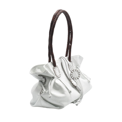 Close-up of embossed Signature logo and pebbled leather texture on the front flap of the satchel.