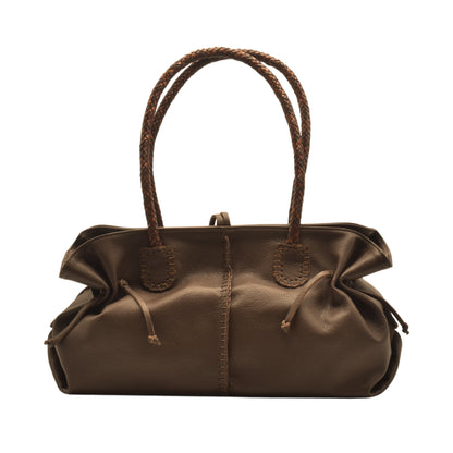 Close-up of textured black leather handle with silver hardware detailing on the Signature Satchel.