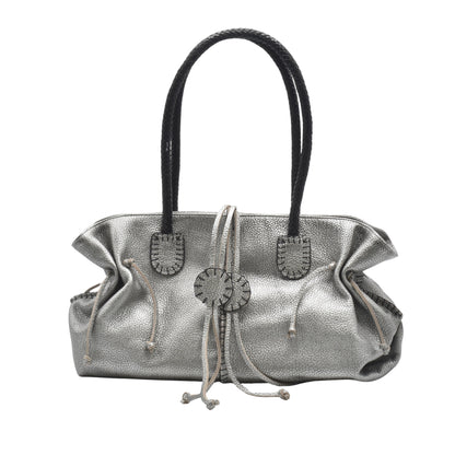 Close-up of textured honey-colored leather handle with subtle stitching on the Signature Satchel, highlighting craftsmanship