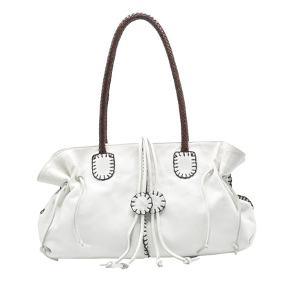 Close-up of textured pebble-grain leather handle detail with reinforced stitching on the Signature Satchel.