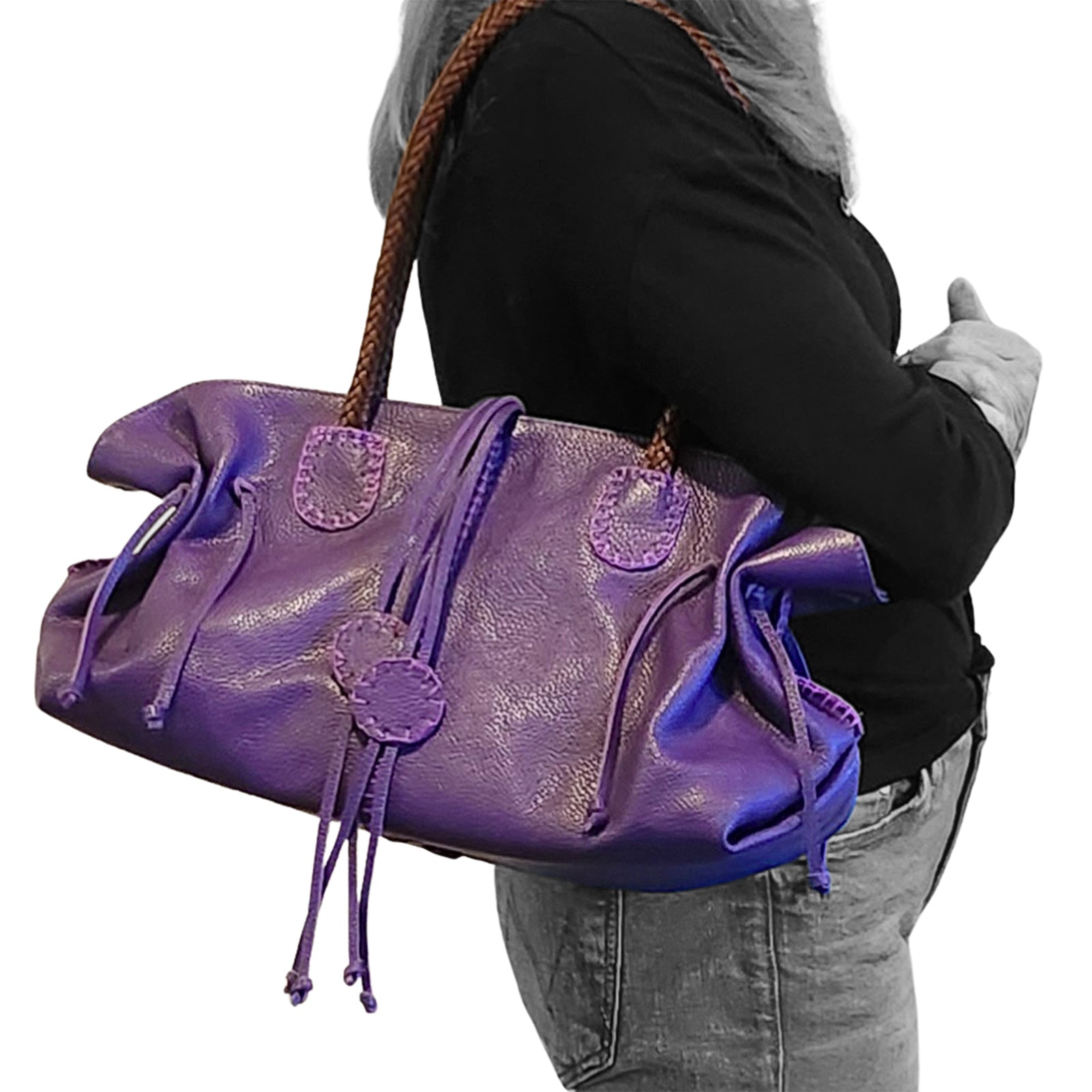 Close-up of the textured pebble-grain leather surface with subtle stitching detail on the Signature Satchel's front corner