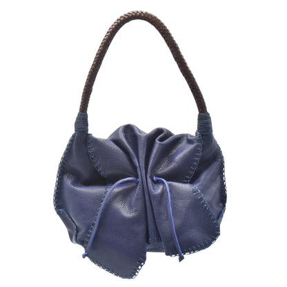 Close-up of gold-tone chain strap with textured leather surface showcasing stitching details and subtle natural grain.