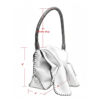 Close-up of the shoulder strap connection with gold-toned hardware and textured leather surface detail.