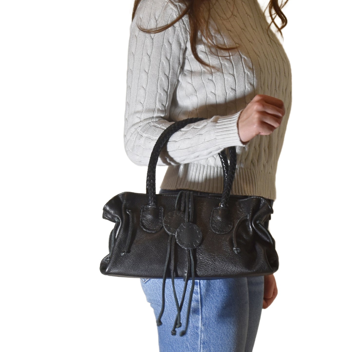 Close-up of the Mini Satchel’s textured leather surface with visible stitching and a silver zipper pull detail.