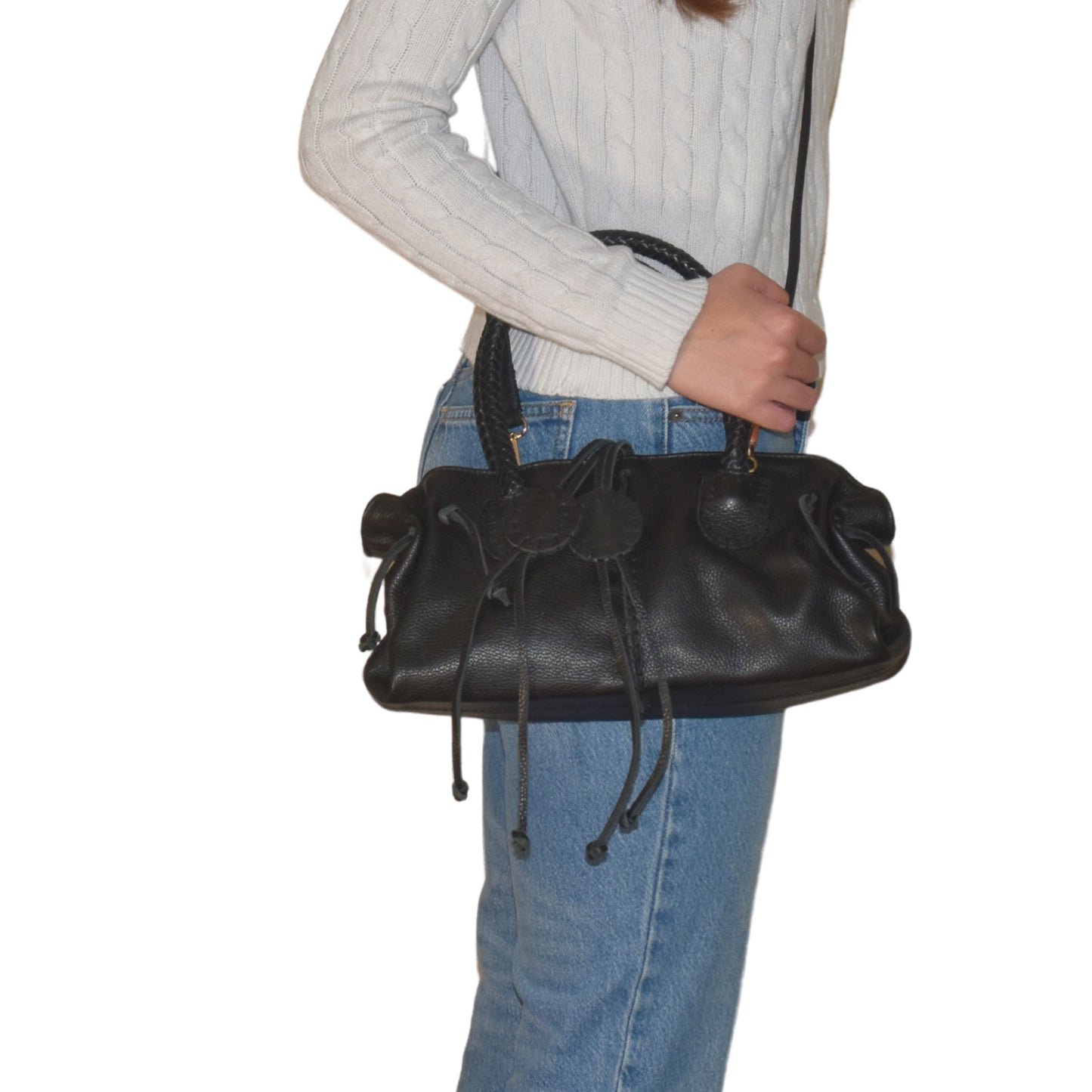 Close-up of the Mini Satchel’s textured pebble leather surface with dark brown stitching and a subtle embossed logo detail.