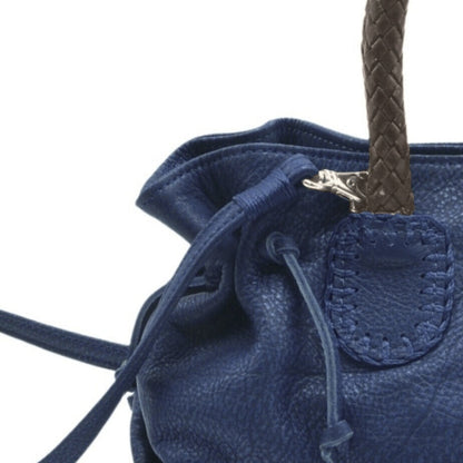 Close-up of the Mini Satchel's textured pebble leather surface with gold-tone zipper pull and stitched edges visible from
