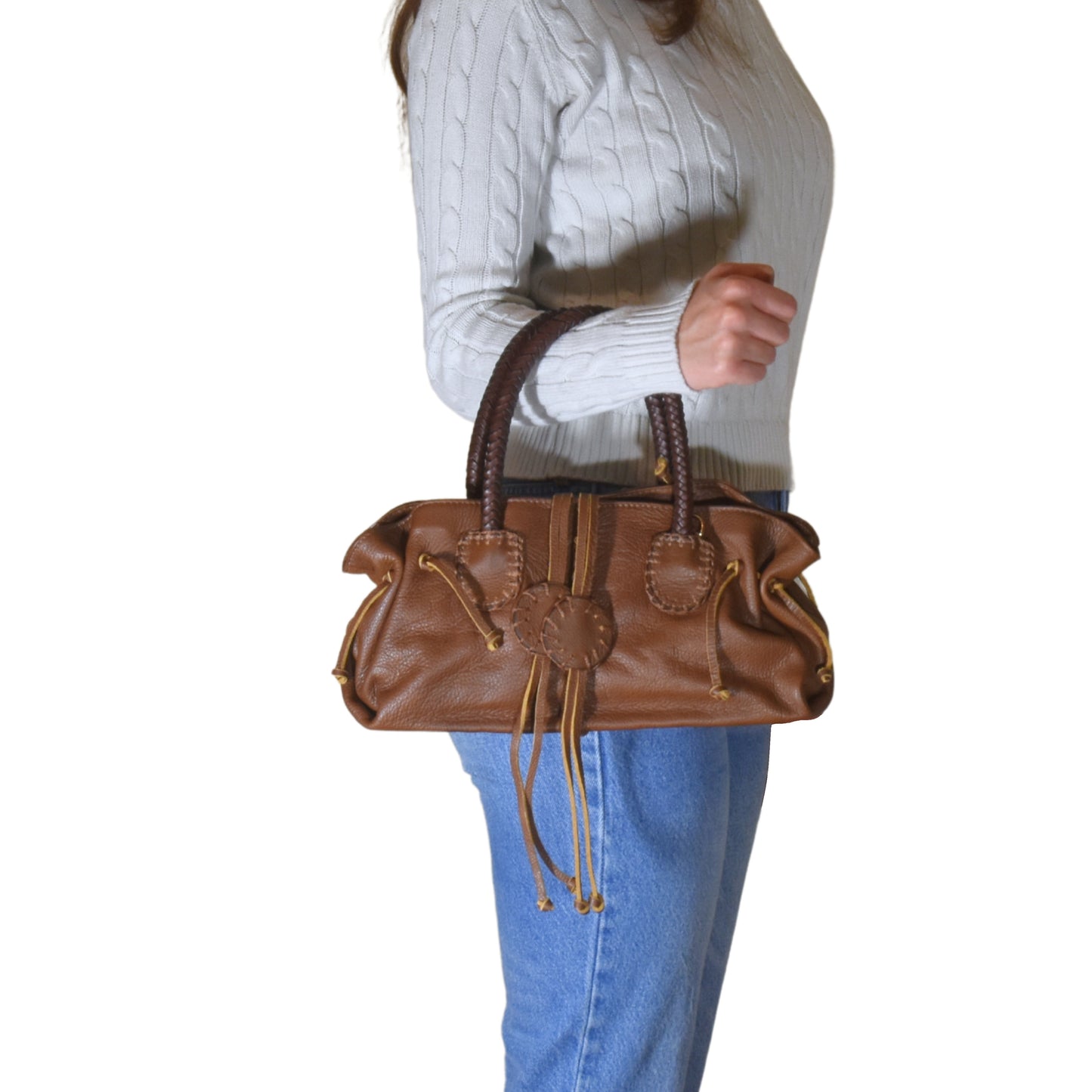 Close-up of the Mini Satchel's textured pebble leather surface with a silver zipper pull and decorative stitching detail.