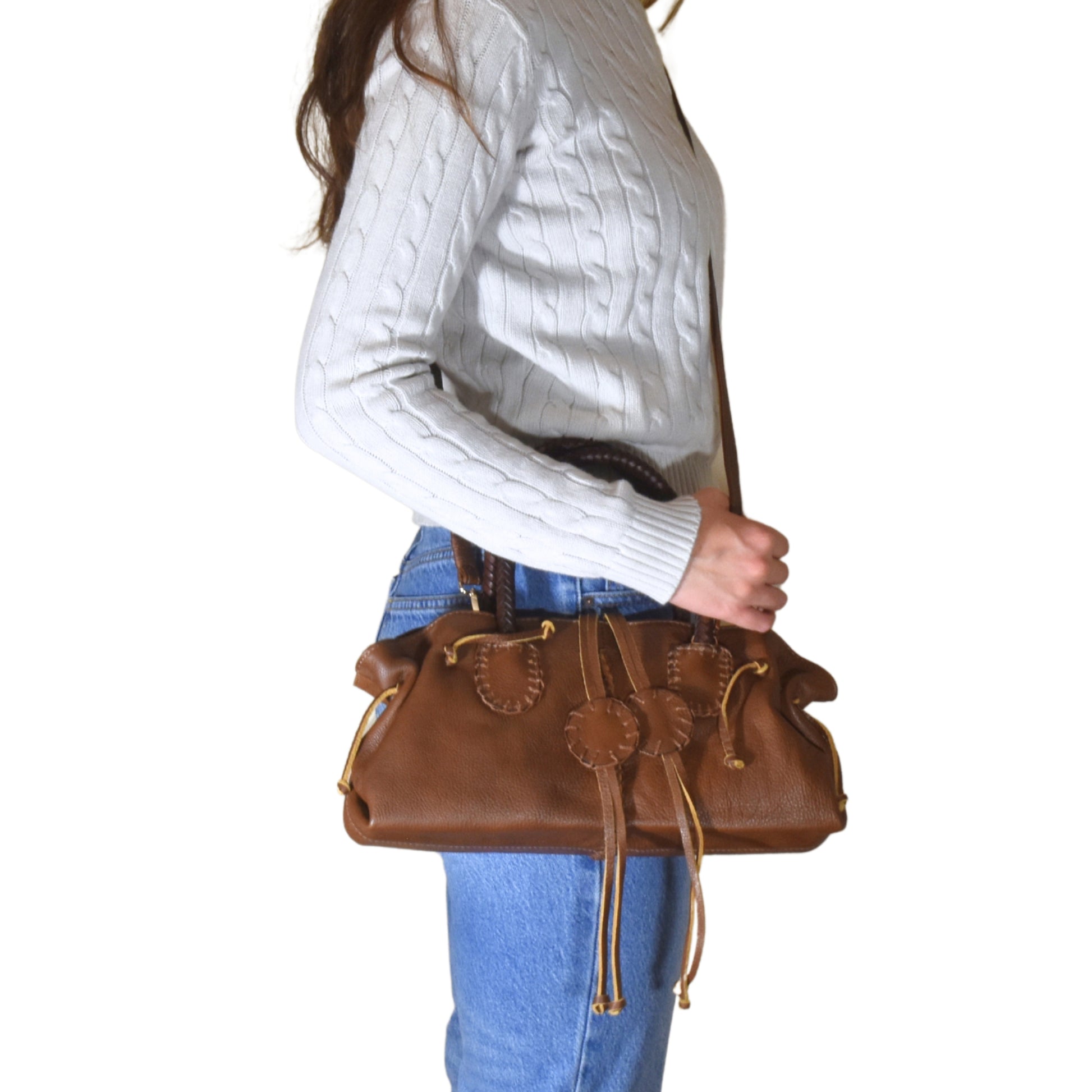 Close-up of the Mini Satchel’s textured pebble leather surface with visible stitching and a gold-tone zipper pull detail.