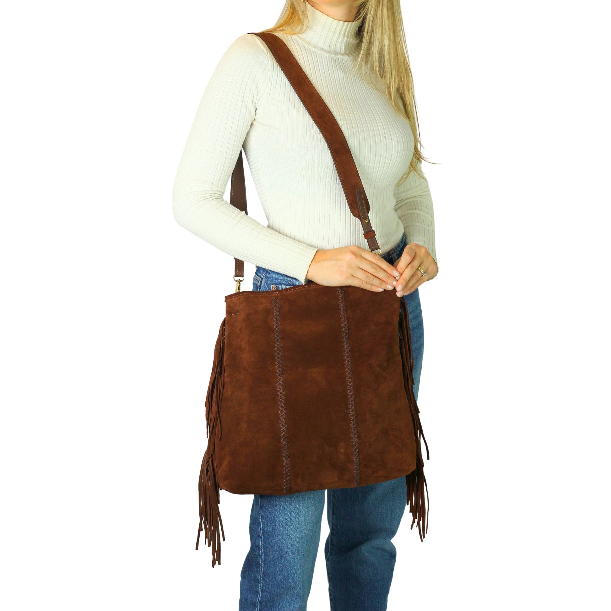 Close-up of the large fringe detailing on the crossbody strap, showcasing textured leather and metallic accents from a side