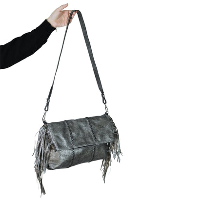 Close-up of the large fringe crossbody strap’s textured leather and silver-toned metal chain detail from an angled bottom