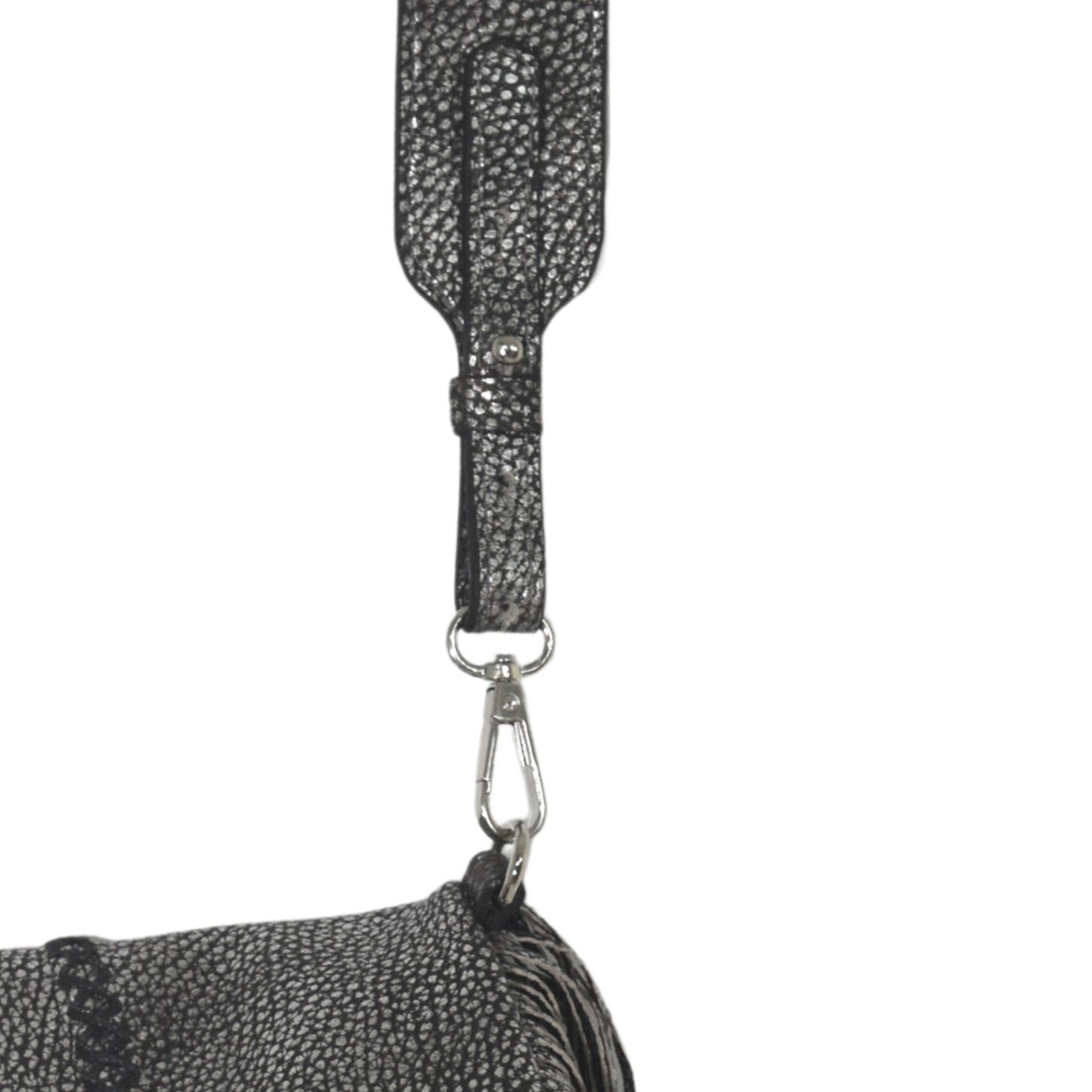 Close-up of the large fringe leather crossbody strap showing detailed stitching and layered tassels from a bottom-up angle.