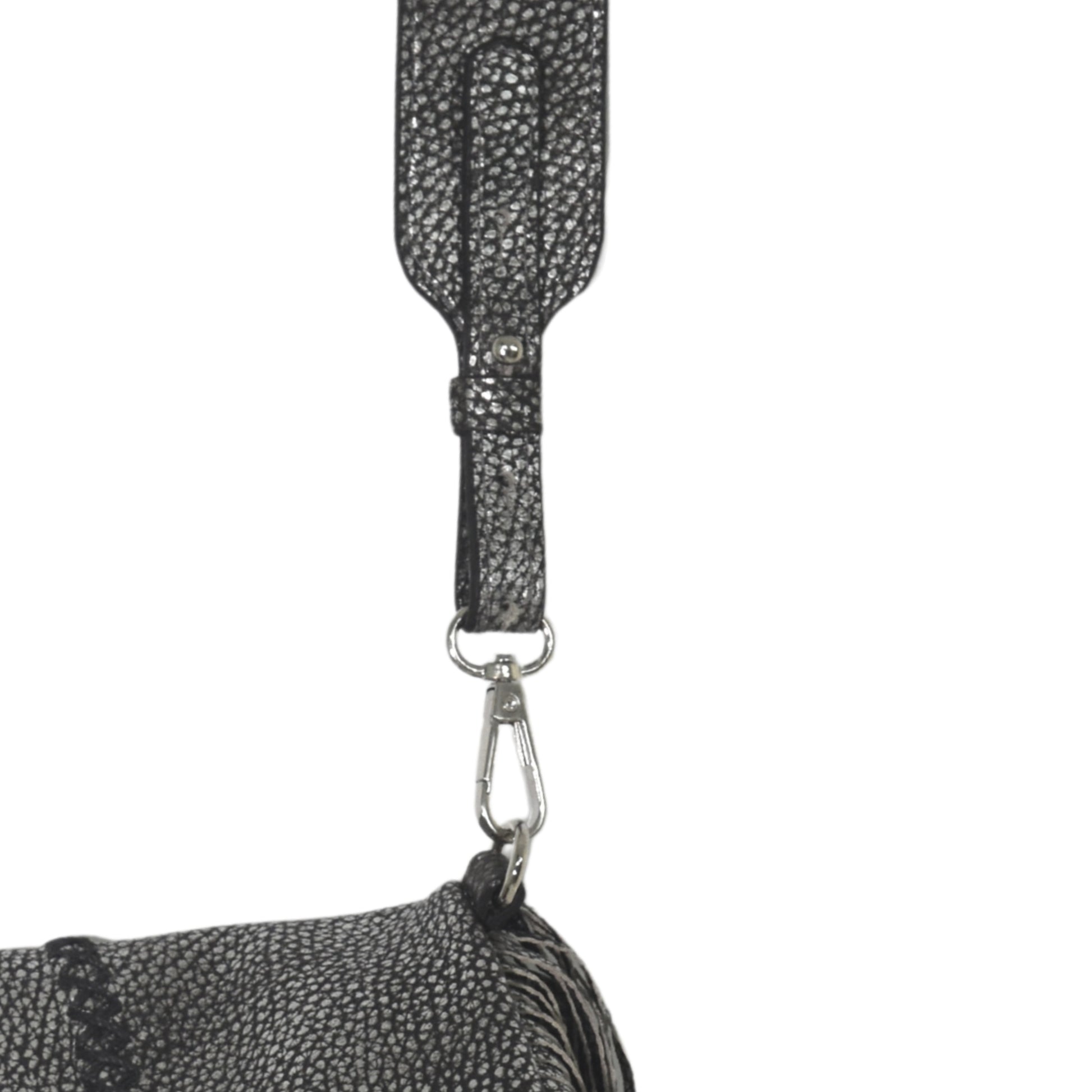 Close-up of the large fringe leather crossbody strap showing detailed stitching and layered tassels from a bottom-up angle.