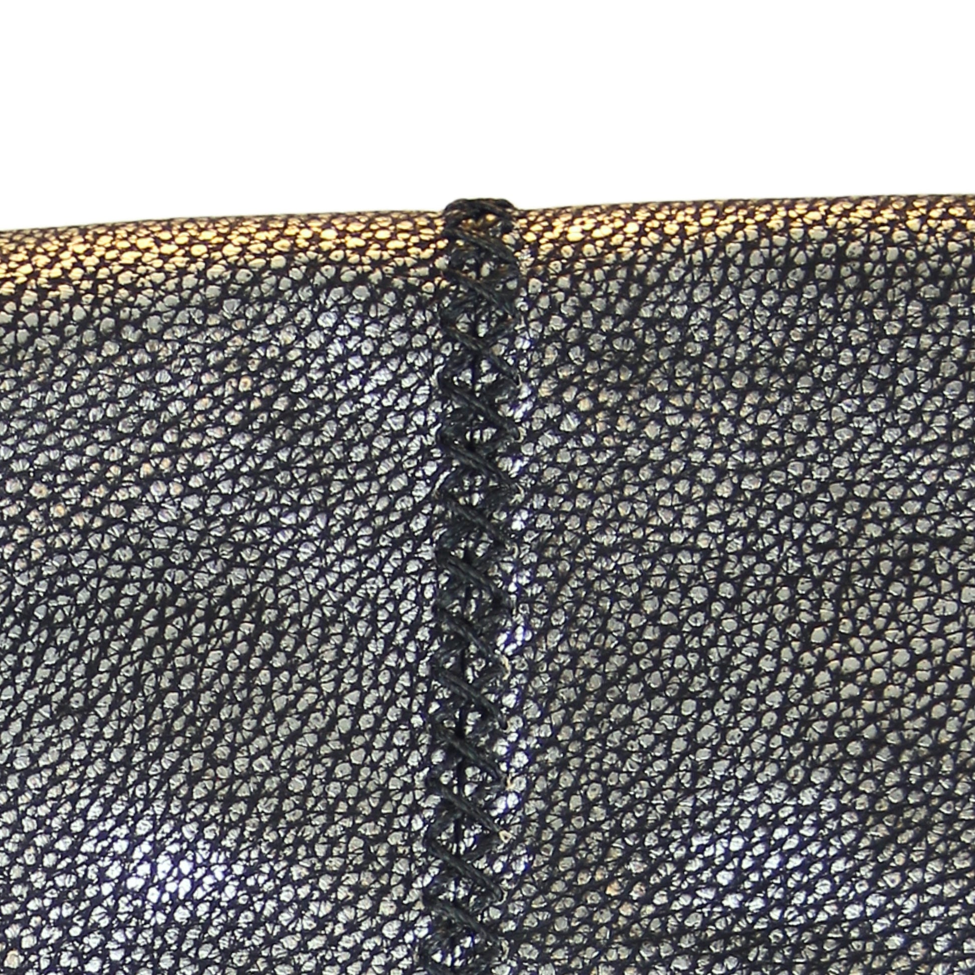 Close-up of the large gold-tone metal fringe detailing with layered chain links and adjustable clasp on the crossbody strap.