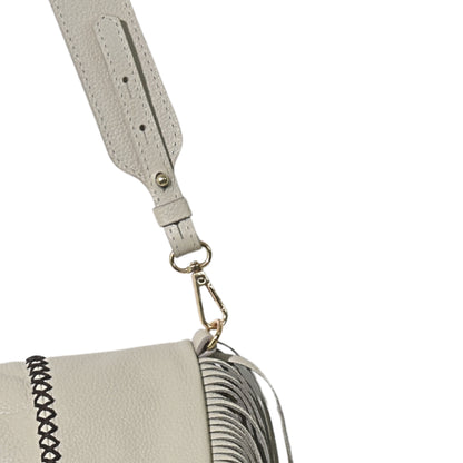 Close-up of the large fringe leather strap with silver-tone metal accents and layered chain detail on the messenger body.