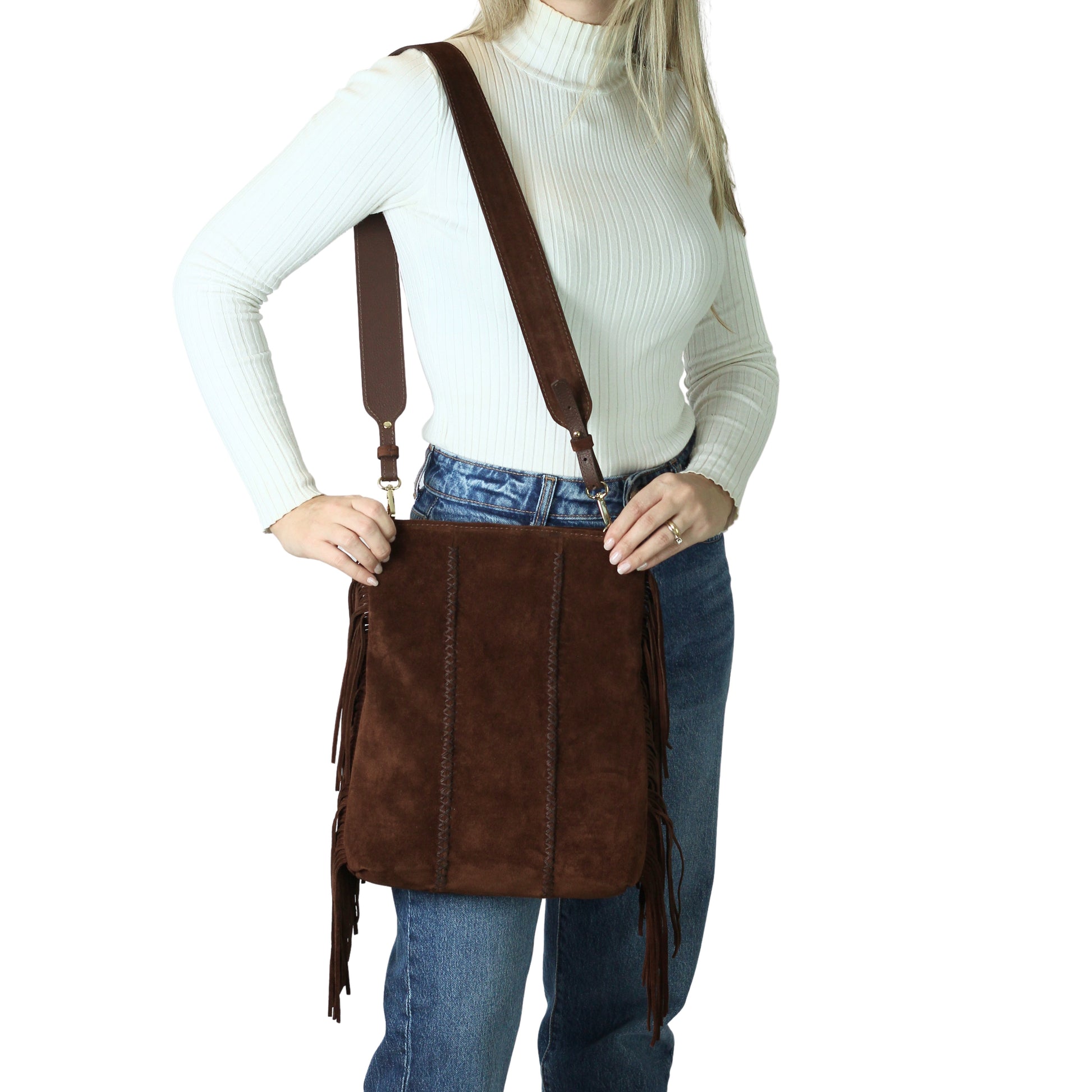 Close-up of the fringed leather flap with metallic silver hardware and engraved logo detail on the Crossbody Messenger.