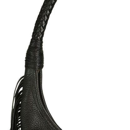 Close-up of the fringe detail and textured leather surface displaying layered tassels on the front of the hobo bag.