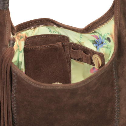 Close-up of the fringed leather detailing on the front flap, highlighting the rustic texture and hand-stitched accents.